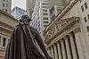 George Washington statue at Federal Hall facing the New York Stock Exchange façade and tall office buildings.