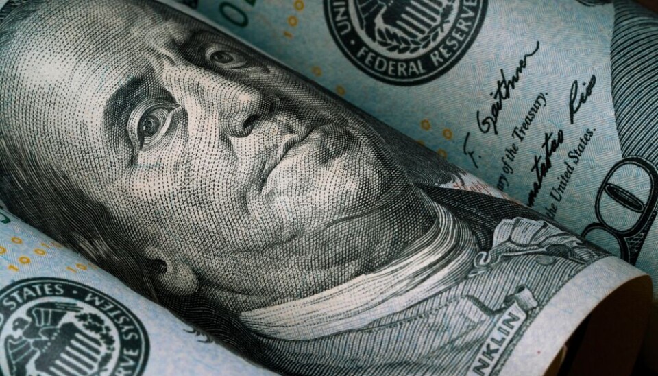 Close-up of Benjamin Franklin on a rolled US $100 banknote.